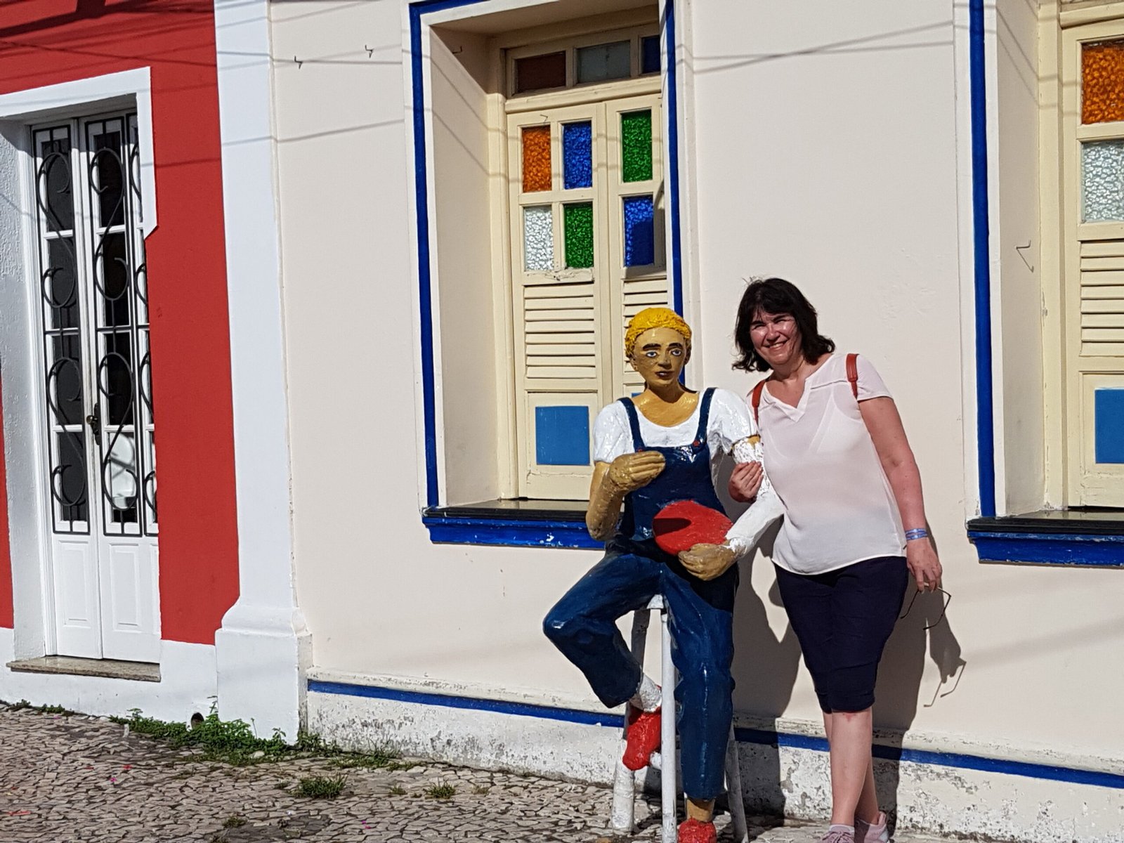 Souvenir de visite devant une façade colorée à Porto Seguro